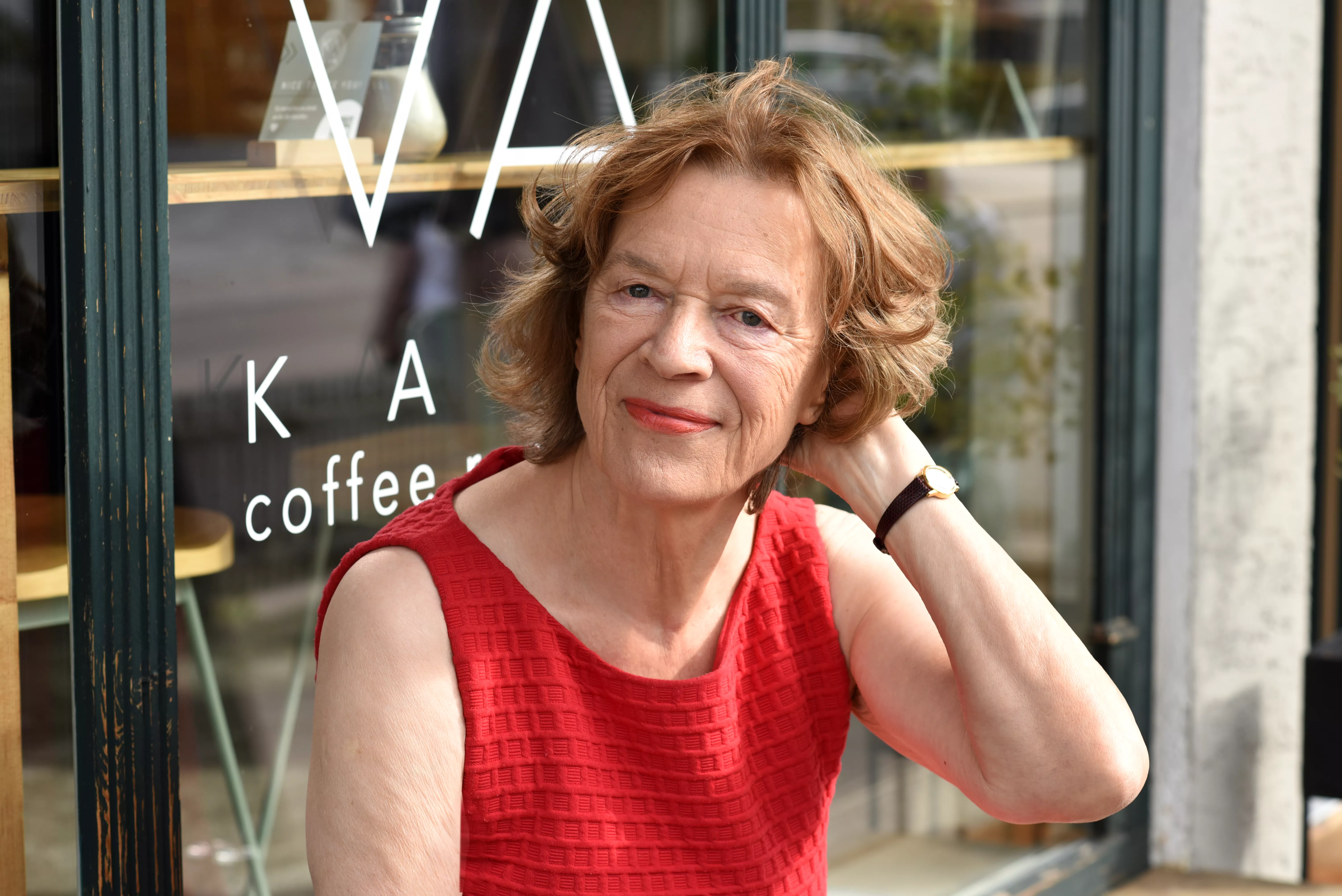 Mara an einem Tisch vor einem Café sitzend Mara an einem Tisch vor einem Café sitzend